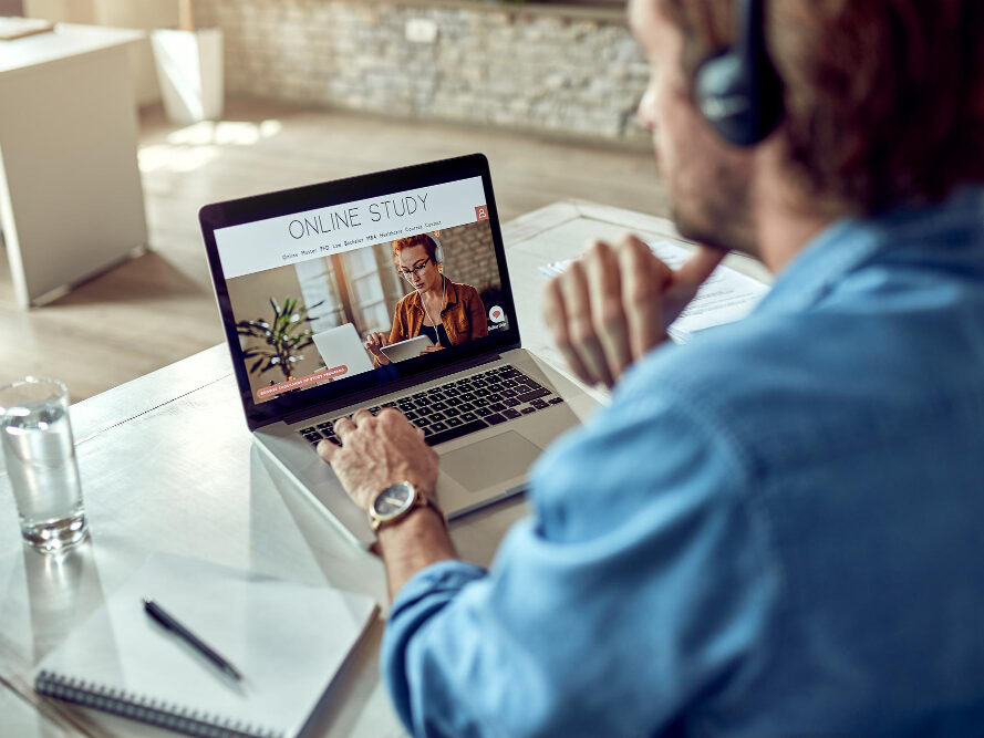 een man kijk op zn laptop die op zn tafel staat.